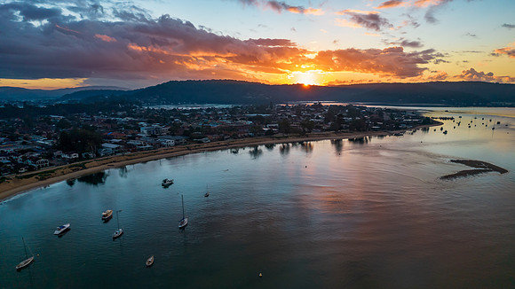 Aerial sunrise waterscape with boats and cloud cover