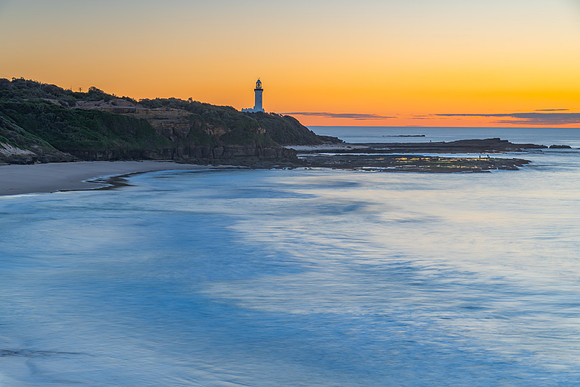Sunrise seascape with lighthouse in the distance
