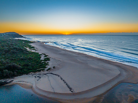 Summer sunrise at the seaside with clouds and haze