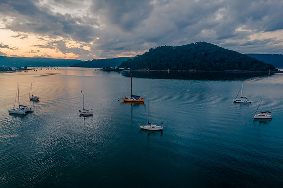 Aerial sunrise waterscape with boats and cloud cover