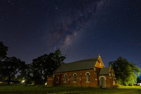 In the dark of the night a church situated under the milky way s