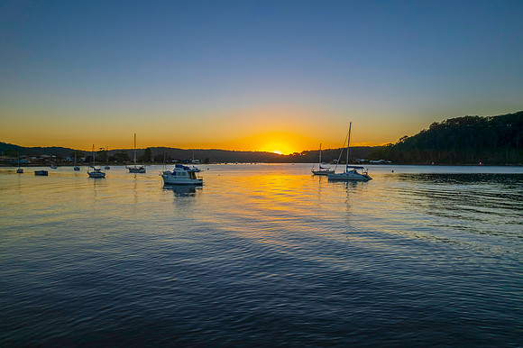 Aerial sunrise waterscape with boats and clear skies