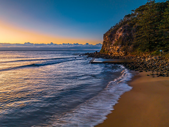 Sunrise at the seaside with low cloud bank and sea pool