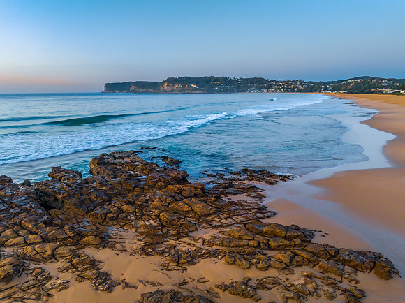 Sunrise over the ocean and rock platform with clear skies