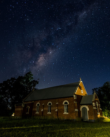 In the dark of the night a church situated under the milky way s