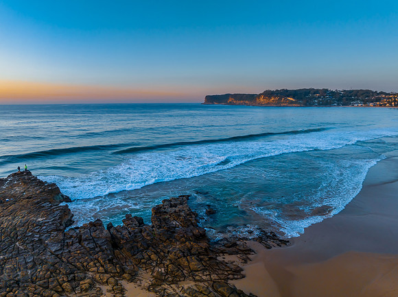 Sunrise over the ocean and rock platform with clear skies