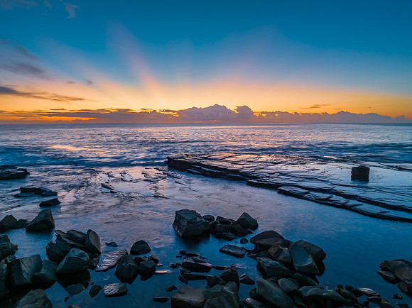 Sunrise over the blue sea and rocky Inlet