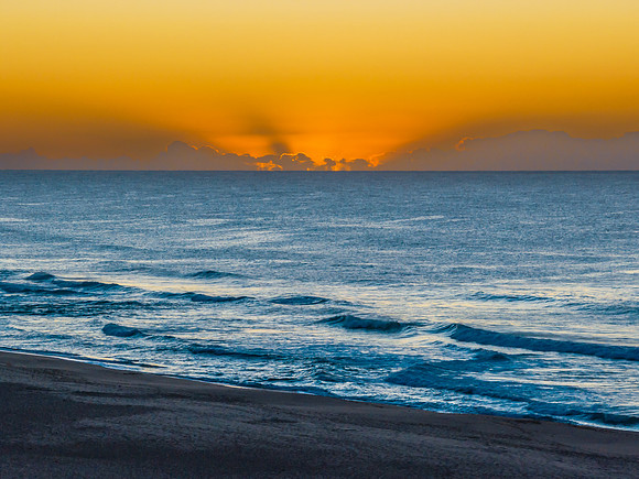Summer sunrise at the seaside with clouds and haze