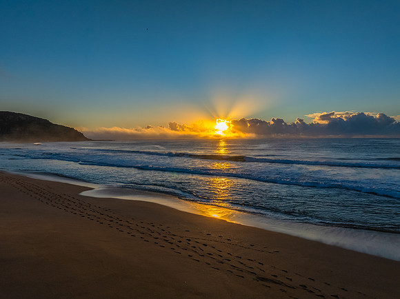 Sunrise over the sea with a low cloud bank and fog