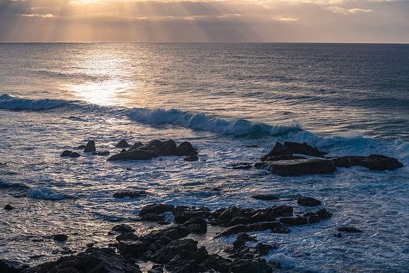 Cloud covered morning with sunrays over the ocean