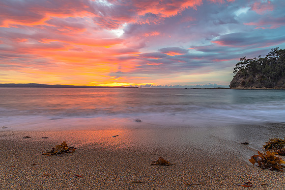 Cloud covered sunrise seascape tinged with pink
