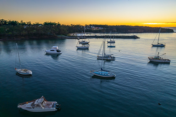 Sunrise over the harbour with low cloud bank and boats