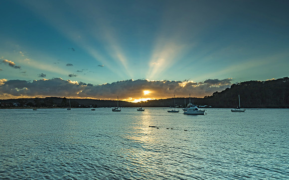 Sunrise Waterscape with Boats and Sun Rays