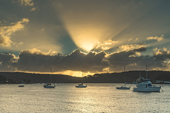 Sunrise Waterscape with Boats and Sun Rays