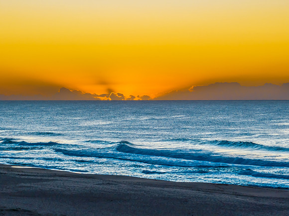Summer sunrise at the seaside with clouds and haze