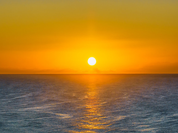 Summer sunrise at the seaside with clouds and haze