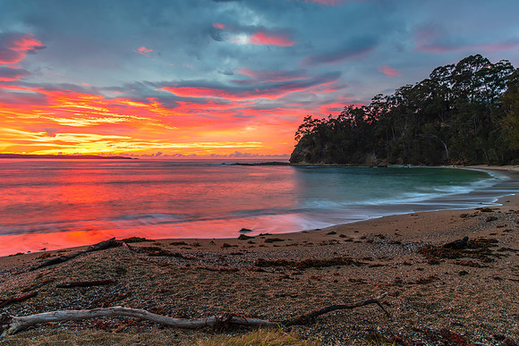 Cloud covered sunrise seascape tinged with pink