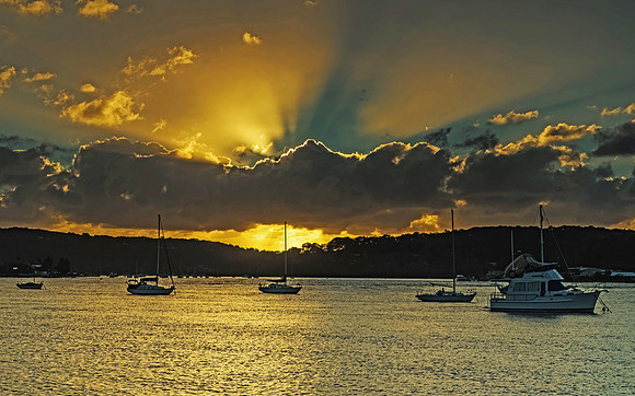Sunrise Waterscape with Boats and Sun Rays