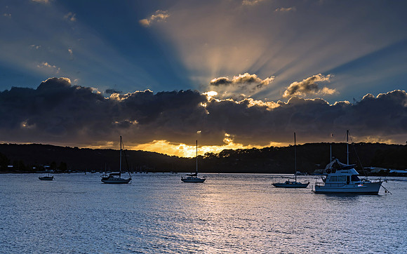Sunrise Waterscape with Boats and Sun Rays