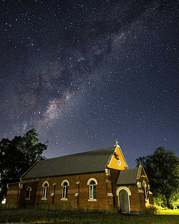 In the dark of the night a church situated under the milky way s