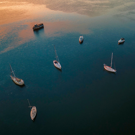 Aerial sunrise waterscape with boats and high cloud