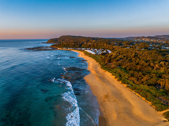 Aerial sunrise seascape with a hazy sky from fire reduction burn