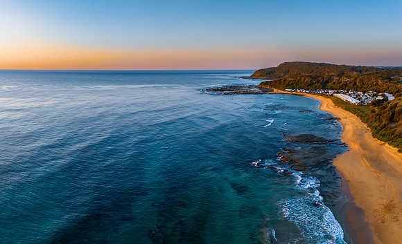 Aerial sunrise seascape with a hazy sky from fire reduction burn
