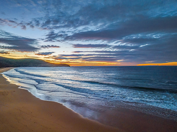 Surf, sea, sand, sunrise with clouds