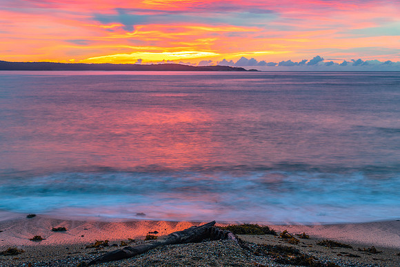 Cloud covered sunrise seascape tinged with pink