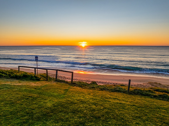 Sunrise at the seaside with clear skies and orange horizon