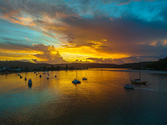 Aerial sunrise waterscape with boats, colour and clouds