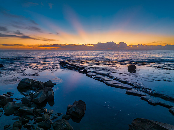 Sunrise over the blue sea and rocky Inlet