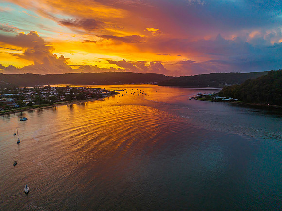 Aerial sunrise waterscape with boats, colour and clouds