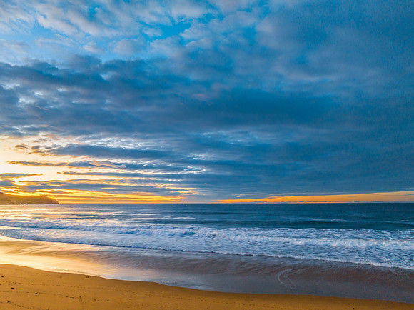 Surf, sea, sand, sunrise with clouds