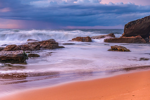 Sunrise seascape with low clouds and waves