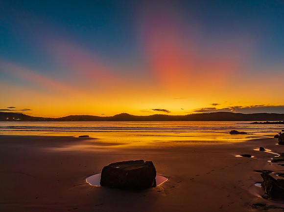 Aerial sunrise at the beach with sun rays in a clear sky
