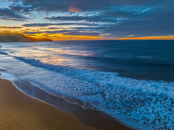 Surf, sea, sand, sunrise with clouds