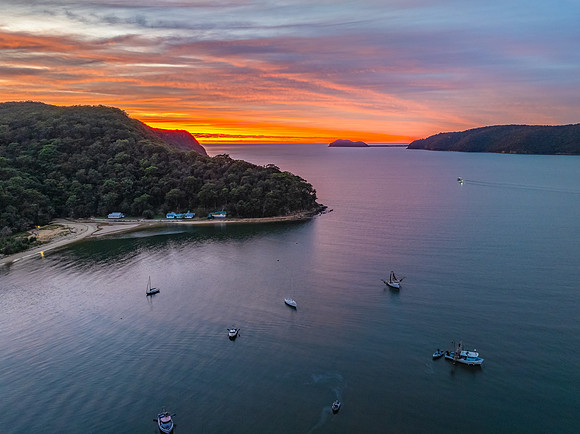 Sunrise over the bay with boats and cloud covered sky