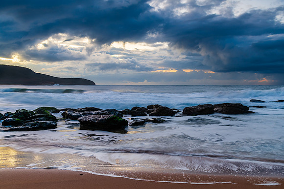 Sunrise seascape with low clouds and waves