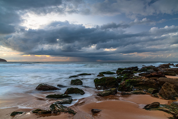 Sunrise seascape with low clouds and waves