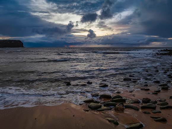 Moody sunrise seascape with rain clouds