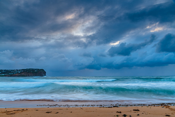 Wet weather sunrise with choppy waves at the seaside