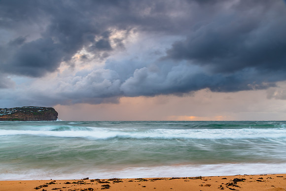 Wet weather sunrise with choppy waves at the seaside