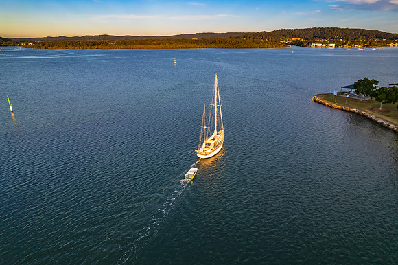 Late afternoon aerial waterscape over the bay with a sail boat