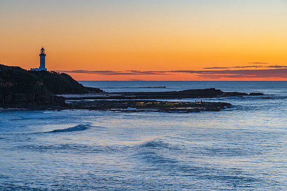 Sunrise seascape with lighthouse in the distance