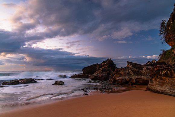 Sunrise seascape with low clouds and waves
