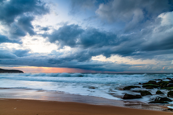 Sunrise seascape with low clouds and waves