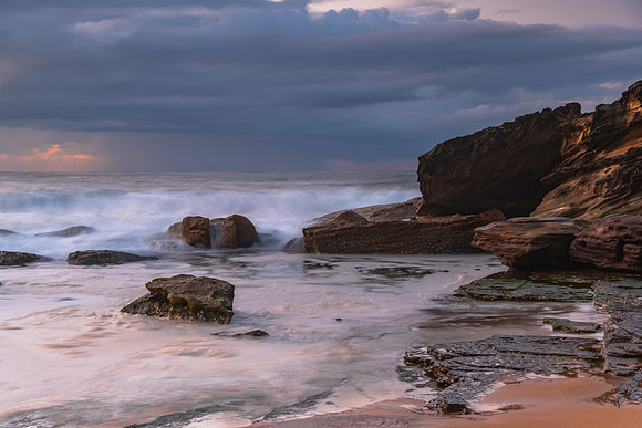 Sunrise seascape with low clouds and waves