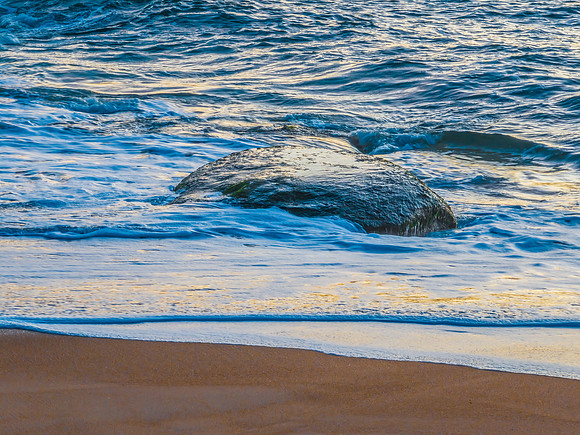 Aerial sunrise views over the ocean, beach and rock