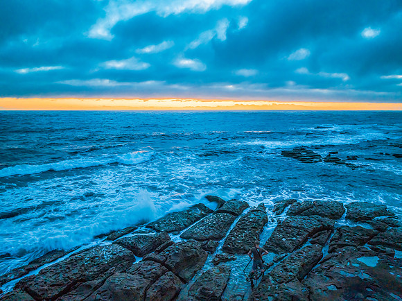 Cloudy sunrise over the ocean with rock platform